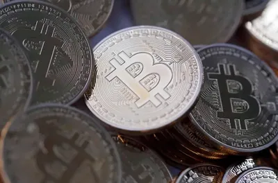 Foto de várias moedas de Bitcoin empilhadas, de forma desorganizada