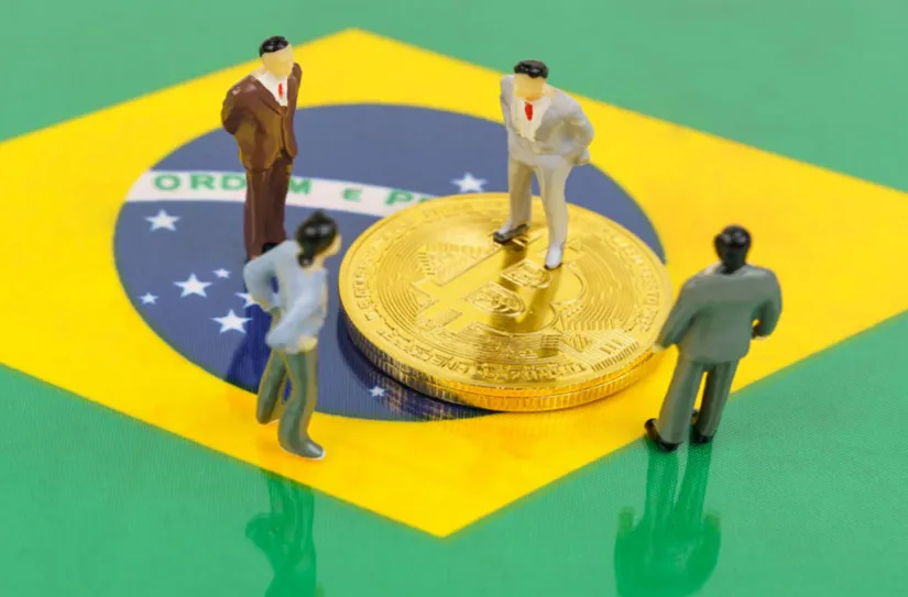 Ilustação de empresários em cima da bandeira do Brasil e de uma moeda de Bitcon