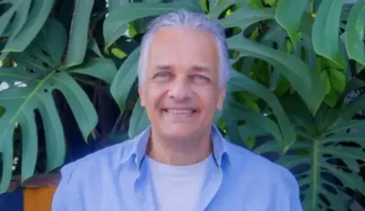 Fábio Moraes, ele é um homem de cabelos grisalhos, sorrindo para a foto.