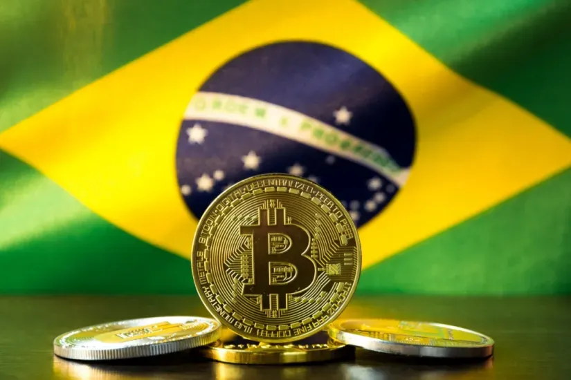 Moeda de bitcon com bandeira do Brasil ao fundo